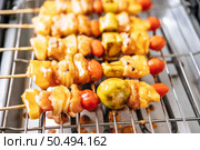 BBQ grill with a variety of meats, complete with tomatoes and bell peppers. Стоковое фото, агентство Ingram Publishing / Фотобанк Лори