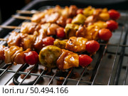 BBQ grill with a variety of meats, complete with tomatoes and bell peppers. Стоковое фото, агентство Ingram Publishing / Фотобанк Лори