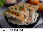 Gyoza in a black cup with Sushi. Selective focus. Стоковое фото, агентство Ingram Publishing / Фотобанк Лори