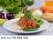 Stir-fried noodles with minced pork, edamame, tomatoes and mushrooms in a white plate. Стоковое фото, агентство Ingram Publishing / Фотобанк Лори