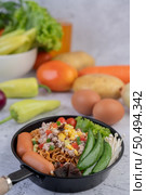 Stir-fried noodles with minced pork, edamame, tomatoes and mushrooms in a pan. Стоковое фото, агентство Ingram Publishing / Фотобанк Лори