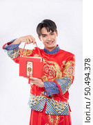 Man wear Cheongsam ready to give red bag to sister for surprising in traditional day. Стоковое фото, агентство Ingram Publishing / Фотобанк Лори
