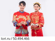 Chinese new year, men and women wear Cheongsam smile to get - give the gift money and cash to relative. Стоковое фото, агентство Ingram Publishing / Фотобанк Лори