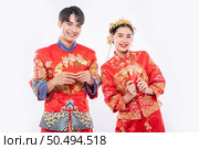 The  Man and woman wear cheongsam smile to receive the gift money from their relative in traditional day. Стоковое фото, агентство Ingram Publishing / Фотобанк Лори