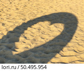 Leftover projection of heart-shaped shadow of structure on beach sand with numerous footprints. Стоковое фото, агентство Ingram Publishing / Фотобанк Лори