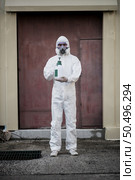 Portrait Disinfection specialist man in PPE suit, gloves, mask and face shield performing public decontamination, standing  and show bottle for spray disinfectant to remove covid-19  . Стоковое фото, агентство Ingram Publishing / Фотобанк Лори