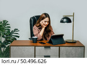 Happily Young asian woman with new normal, she Stay at home and works from home on digital tablet and use smartphone during self-isolation and quarantine covid-19 coronavirus outbreak. Стоковое фото, агентство Ingram Publishing / Фотобанк Лори
