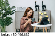 Portrait of smiling happy woman relaxing with coffee, using technology of digital pen on tablet to working from home during self-isolation and quarantine covid-19 coronavirus outbreak. Стоковое фото, агентство Ingram Publishing / Фотобанк Лори