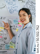 Young asian woman smiling and present planing of project on board in meeting room, copy space. Стоковое фото, агентство Ingram Publishing / Фотобанк Лори