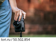 Back view, Close up hand of young photographer woman holding digital camera while traveling in ancient site, copy space. Стоковое фото, агентство Ingram Publishing / Фотобанк Лори