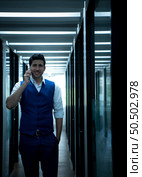 Business man in the corridor of the conference room, Talking to an assistant on the phone to ask for some details. To present results and new projects to the management team for consideration. Стоковое фото, агентство Ingram Publishing / Фотобанк Лори