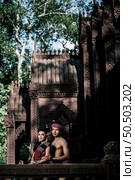 Young Actor and Actress wearing beautiful ancient costumes, in ancient monuments, dramatic style. Perform on legend love popular story, Thai Isan folktale called "Phadaeng and Nang-ai" in acient site. Стоковое фото, агентство Ingram Publishing / Фотобанк Лори