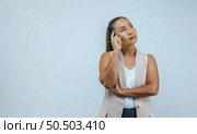 Portrait of Asian woman wearing casual clothes pointing with a finger at the head and looking away at empty space aside, isolated over background in studio. Стоковое фото, агентство Ingram Publishing / Фотобанк Лори