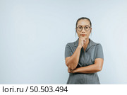 Portrait of Serious Asian woman glasses 30s in casual clothes looking at camera and put hand prop up on chin isolated on wall background in studio. Mock up copy space. Стоковое фото, агентство Ingram Publishing / Фотобанк Лори