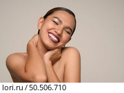 Head shot, portrait of cheerful woman use hand place on neck, hugging herself feelings with toothy smile posing isolated on gray background in studio, copy space. Стоковое фото, агентство Ingram Publishing / Фотобанк Лори