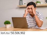 Male employee working in office with laptop and stressed. Стоковое фото, агентство Ingram Publishing / Фотобанк Лори