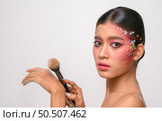 woman wearing pink makeup and holding a blush brush. Isolated on white background. Стоковое фото, агентство Ingram Publishing / Фотобанк Лори