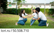 Vacation for a young family Spend this priceless time together playing on the village lawn. A little girl was slightly injured while playing with her parents comforting her at her side. Стоковое фото, агентство Ingram Publishing / Фотобанк Лори