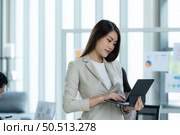 Portrait of an Asian female rookie in the new entrepreneurial team in the business of investment services. Стоковое фото, агентство Ingram Publishing / Фотобанк Лори