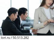 Young entrepreneurs in Asia Meeting to review stock investment information in the meeting room with a coordinator to facilitate various aspects to serve. Стоковое фото, агентство Ingram Publishing / Фотобанк Лори