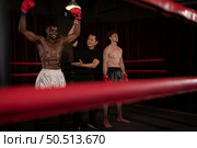 Victorious boxer the referee will raise their hands on stage, Muay Thai, Thai martial arts. Стоковое фото, агентство Ingram Publishing / Фотобанк Лори