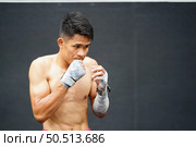 Muay Thai, The martial art of Thailand, The boxer’s rehearsal punching before the real fight on the stage It prepares the body for each boxing match. Стоковое фото, агентство Ingram Publishing / Фотобанк Лори