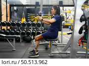 Young female with one prosthetic leg with shoulder exercises with exercise machines to train the muscles in the torso and shoulders, the concept of living a woman’s life with a prosthetic leg. Стоковое фото, агентство Ingram Publishing / Фотобанк Лори