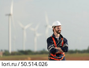 Engineer at Natural Energy Wind Turbine site with a mission to climb up to the wind turbine blades to inspect the operation of large wind turbines that converts wind energy into electrical energy. Стоковое фото, агентство Ingram Publishing / Фотобанк Лори