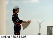 Engineer at Natural Energy Wind Turbine site with a mission to climb up to the wind turbine blades to inspect the operation of large wind turbines that converts wind energy into electrical energy. Стоковое фото, агентство Ingram Publishing / Фотобанк Лори