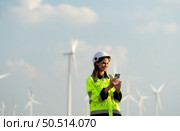 Female engineer at Natural Energy Wind Turbine site with the mission of being responsible for taking care of large wind turbines Use the phone to communicate with your family to get rid of missing you. Стоковое фото, агентство Ingram Publishing / Фотобанк Лори