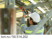 Electrical engineers is inspecting and maintaining solar panels at a solar panel site in the middle of a hundred acre field. Стоковое фото, агентство Ingram Publishing / Фотобанк Лори
