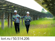 A team of electrical engineers is inspecting and maintaining solar panels at a solar panel site in the middle of a hundred acre field. Стоковое фото, агентство Ingram Publishing / Фотобанк Лори