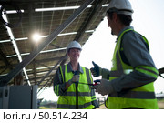 A team of electrical engineers is inspecting and maintaining solar panels at a solar panel site in the middle of a hundred acre field. Стоковое фото, агентство Ingram Publishing / Фотобанк Лори