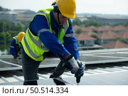 Both of Engineer in charge of solar panel installation The installation of solar energy conversion into electricity for a warehouse is currently being investigated. Стоковое фото, агентство Ingram Publishing / Фотобанк Лори