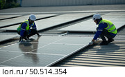 Engineer in charge of solar panel installation The installation of solar energy conversion into electricity for a warehouse is currently being investigated. Стоковое фото, агентство Ingram Publishing / Фотобанк Лори