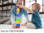 Father with little boy have fun playing with your new toys in the bedroom together. Toys that enhance children’s thinking skills. Стоковое фото, агентство Ingram Publishing / Фотобанк Лори