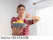 Young female think that french fries is a food that has very little nutritional benefit. On the contrary it is harmful to health in the long run. Стоковое фото, агентство Ingram Publishing / Фотобанк Лори