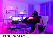 Gamer holding his head with both hands and having a frustrated mood unpleasant when playing a game losing to an opponent. Стоковое фото, агентство Ingram Publishing / Фотобанк Лори