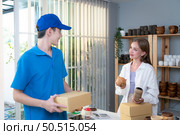 The delivery man brings the goods that the customer purchased and delivers them to the customer’s home. Стоковое фото, агентство Ingram Publishing / Фотобанк Лори