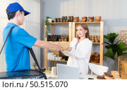 The delivery man brings the goods that the customer purchased and delivers them to the customer’s home. Стоковое фото, агентство Ingram Publishing / Фотобанк Лори
