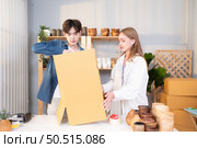 A young couple runs a small business making clay jewelry. They support one another as they work toward becoming larger business in the future. Стоковое фото, агентство Ingram Publishing / Фотобанк Лори