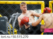 Muay Thai, The martial art of Thailand, The power of a knee into the opponent’s abdomen causing the opponent to have colic, tightness in the stomach and lose by knockout. Стоковое фото, агентство Ingram Publishing / Фотобанк Лори