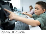 Youngsters utilizing the hand robot technology are having fun learning the electronic circuit board and hand robot controller of robot technology, which is one of the STEM courses. Стоковое фото, агентство Ingram Publishing / Фотобанк Лори