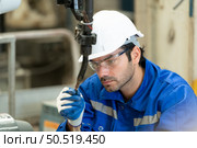 Young male engineers with experience are maintaining and testing the functionality of welding robots. After the hardwork of welding robots. Стоковое фото, агентство Ingram Publishing / Фотобанк Лори