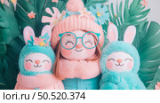 Adorable Girl and Bunny Plushies in Tropical Setting: Pastel Colors, Soft Textures, Happy Mood. Стоковое AI-изображение, AI-художник Данила Большаков / Фотобанк Лори