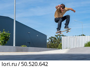 Skateboarder doing ollie trick on a urban scene. Стоковое фото, агентство Ingram Publishing / Фотобанк Лори