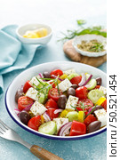 Greek salad. Vegetable salad with feta cheese, tomato, olives, cucumber, red onion and olive oil. Healthy vegetarian mediterranean diet food. Стоковое фото, агентство Ingram Publishing / Фотобанк Лори