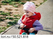 Joyful Girl Riding a Scooter on a Sunny Playground in Vibrant Outdoor Setting. Стоковое фото, фотограф Aleksandr Golubev / Фотобанк Лори