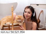 Young asian woman snuggling with a clever Persian cat. with love tenderness. Стоковое фото, агентство Ingram Publishing / Фотобанк Лори