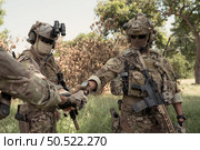 Special forces soldier in camouflage, fist bump and send energy to each other before performing an attack on. Стоковое фото, агентство Ingram Publishing / Фотобанк Лори